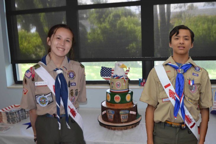Sister and brother Marina and Grant Mitchell pose with a cake during a celebration for both obtaining the rank of Eagle Scout.